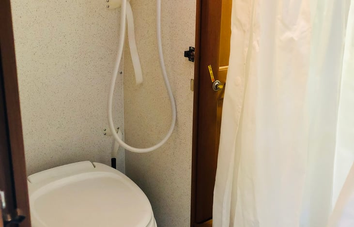 Bathroom is a temporary aisle-style. Simply open both cabinet doors to create privacy (or use the shower curtain instead for slightly less privacy and quicker set-up!)