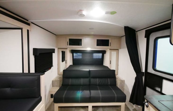 Additional seating is provided with a couch that seats 3 adults and a kitchen dinette that seats 4 adults. The dinette table can fold down into a full size RV bed that can sleep 1 adult/ 2 kids.