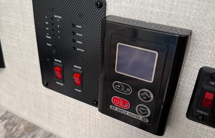 Black and gray tank controls and water heater control - located to the right in the bathroom.