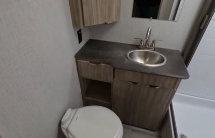 full size bathroom with porcelain toilet.