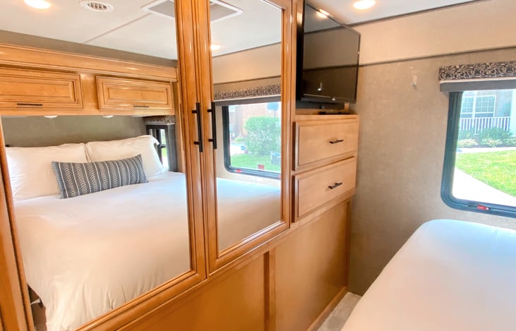 Carpeted master bedroom includes TV. Slide provides additional walking space.