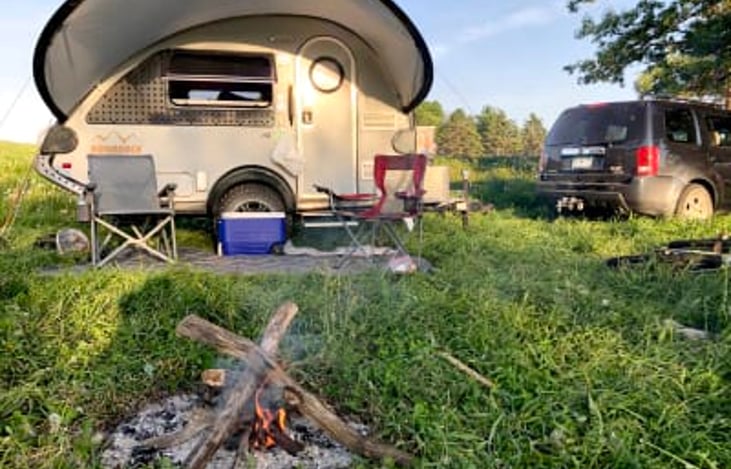 "Sun-Chaser" fully setup for a hiking/biking/trout fishing/camping weekend. The fire is going for dinner with the sun setting over the stream & hills.