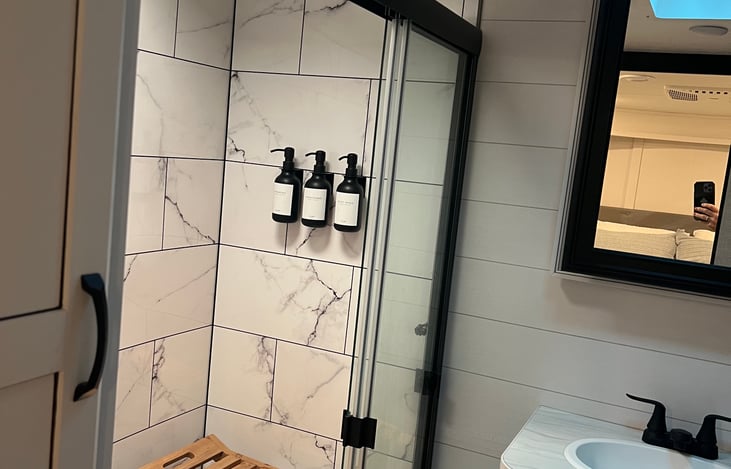 Large shower with teak bench.