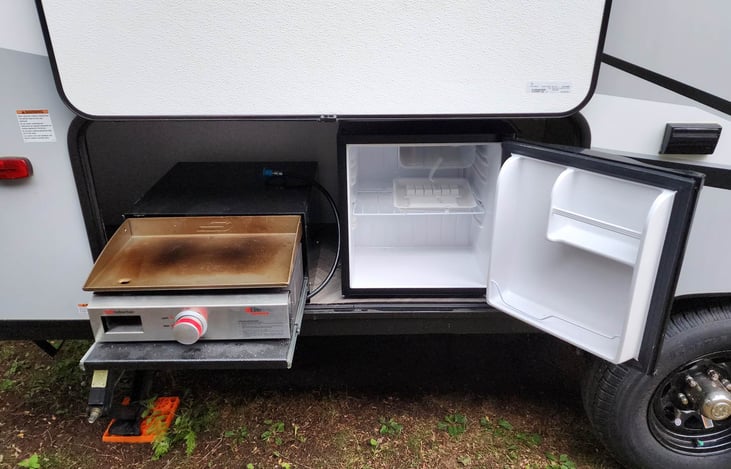 Outdoor griddle & fridge (Single Serve Mini-K Keurig behind open fridge door) - Passenger Side - There's also citronella candles, outdoor rug & fire starters in this cubbie.