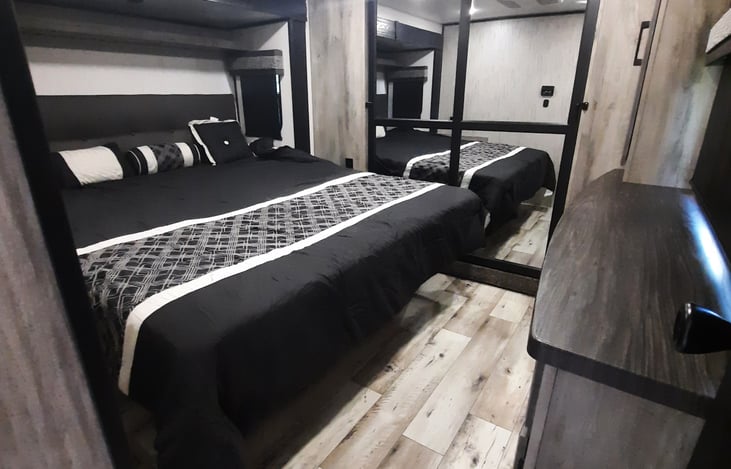 Master bedroom with king size bed, large closet space and dresser.