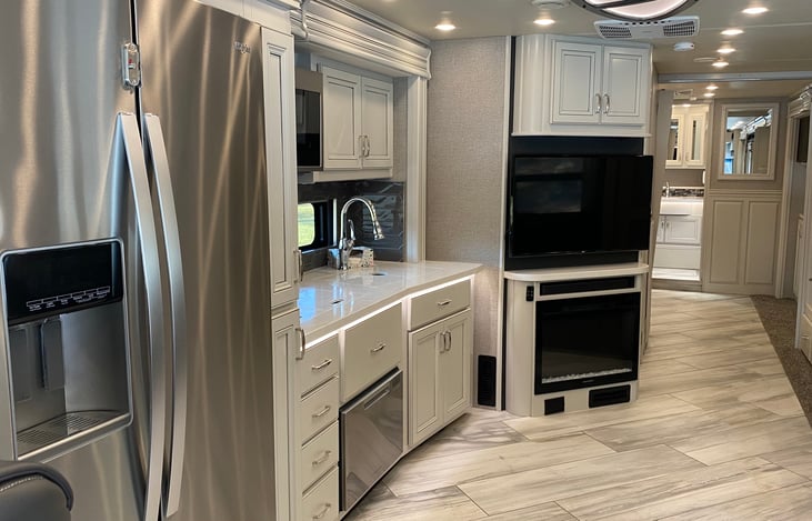 mid coach, TV and kitchen area with full size refrigerator.