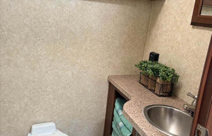 Bathroom with towels, supplies, and plenty of cabinet space.