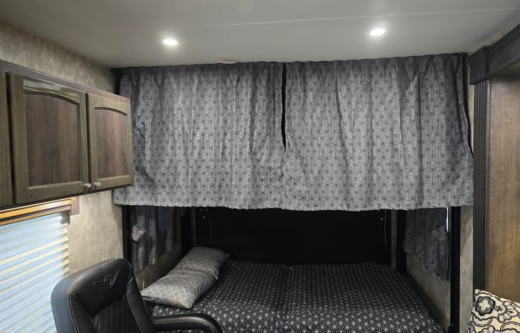 Top bunk with privacy curtains.