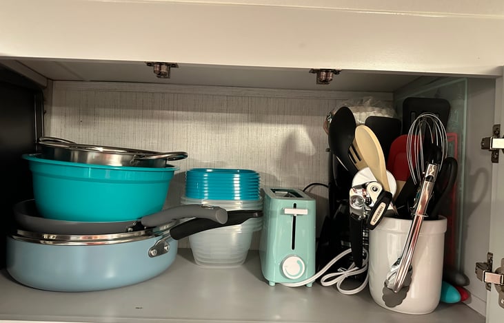 Coffee pot and filters, toaster, cooking utensils, knives, cutting boards, food storage, large pot, frying pan, mixing bowl, and strainer.