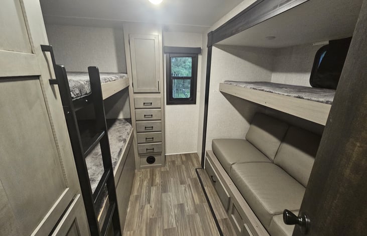 2 full size bunks on the left and one single bunk on the right along with a fold out jackknife sofa that sleeps 1 comfortably, possibly 2 people.
