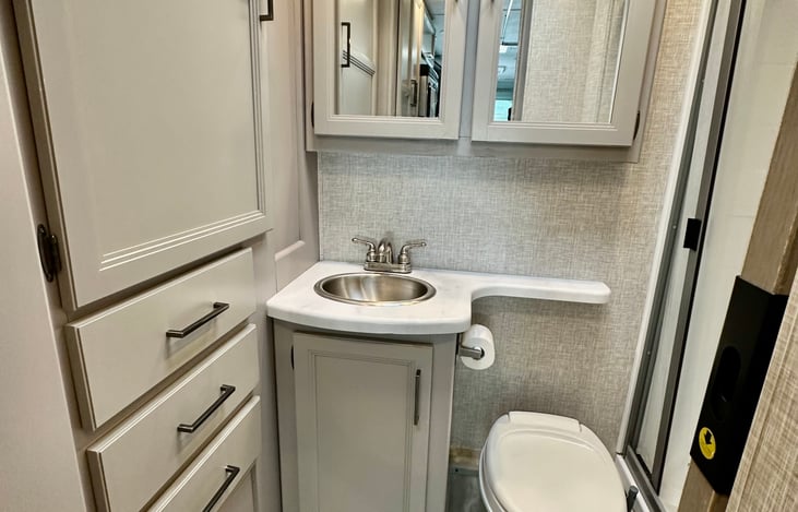 Roomy bathroom with pocket door for privacy.