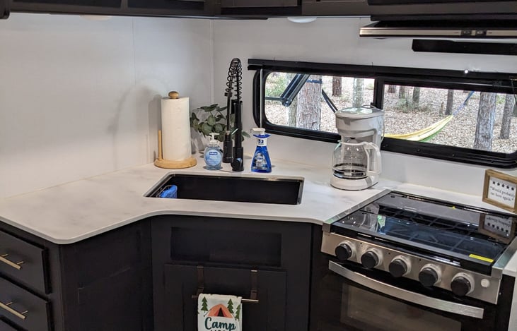 Beautiful Kitchen with deep sink, high-rise spring pull-out kitchen faucet, gas stove, oven, and microwave.