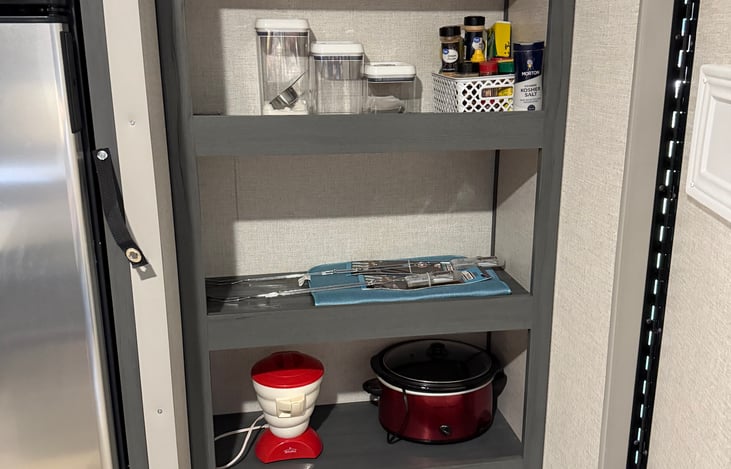 Hidden pantry behind the TV and fireplace. Dog bowls ready for your pets!
