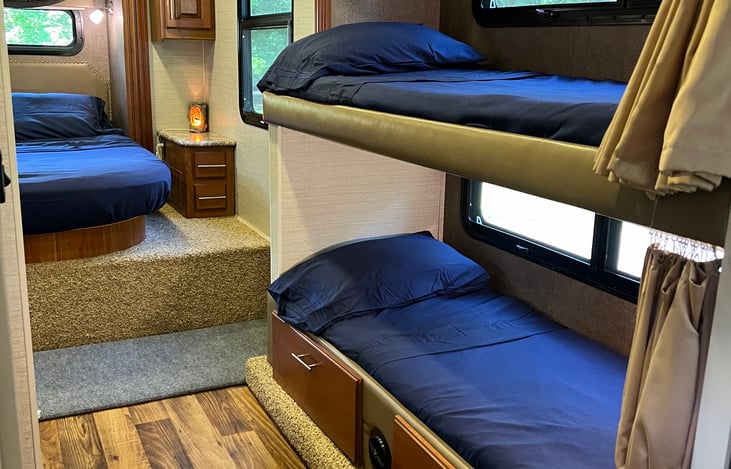 Twin bunks with their own curtains for privacy, windows and lights