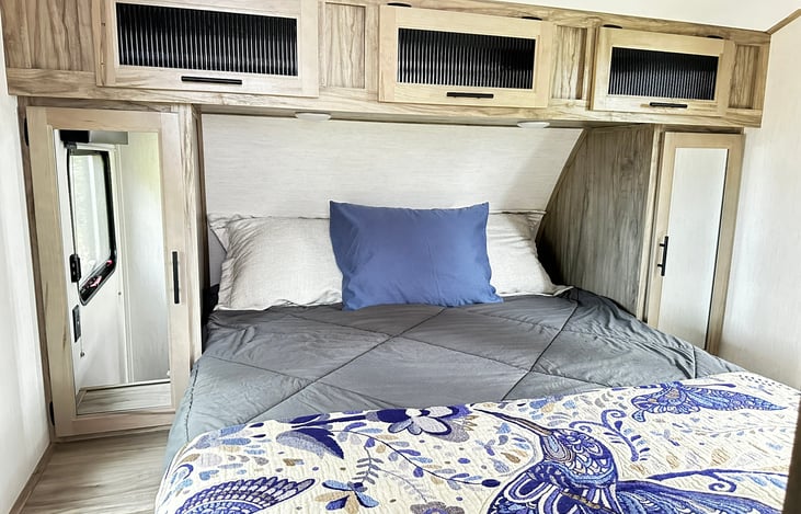 Basic RV Bedroom fully stocked with quality linens, robes for your use, and even a step stool to help us vertically challenged souls :)