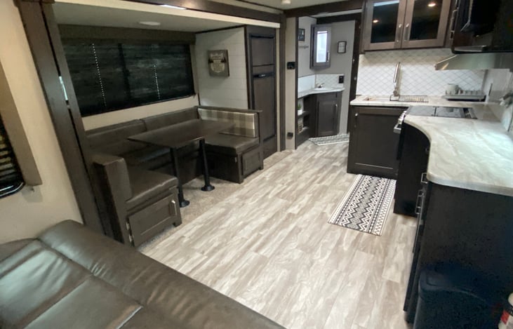 large living/kitchen area with conversational setup and swivel mounted TV.