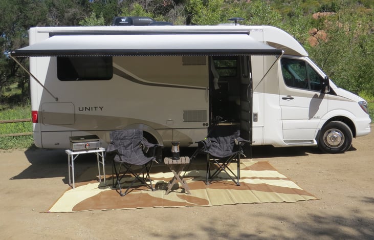 Electric awning, chairs, propane griddle, tables and outdoor rug too!