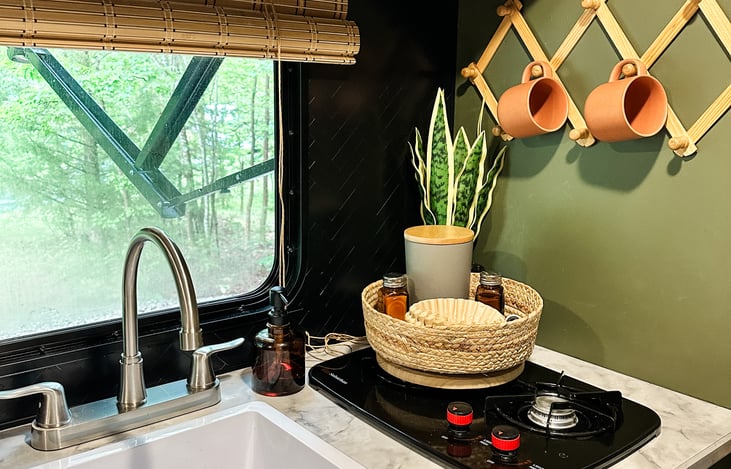 Our RV for rent includes a two-burner propane cooktop and sink situated directly in front of a large exterior window. This allows you to keep an eye on the kids as you prepare a meal or sip coffee.