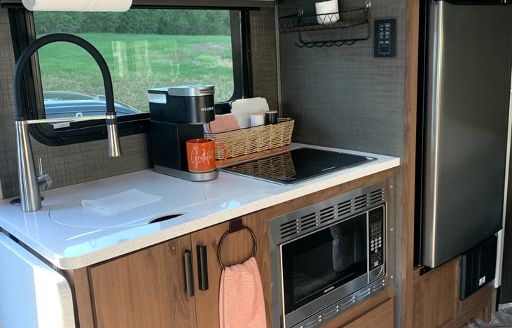 Kitchen with sink, stove, microwave convection oven and residential refrigerator.