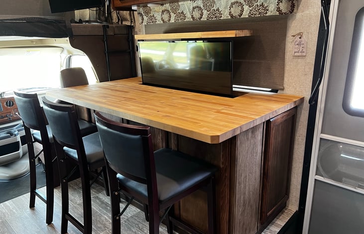 Seating for three at the bar with a TV that raises and lowers.