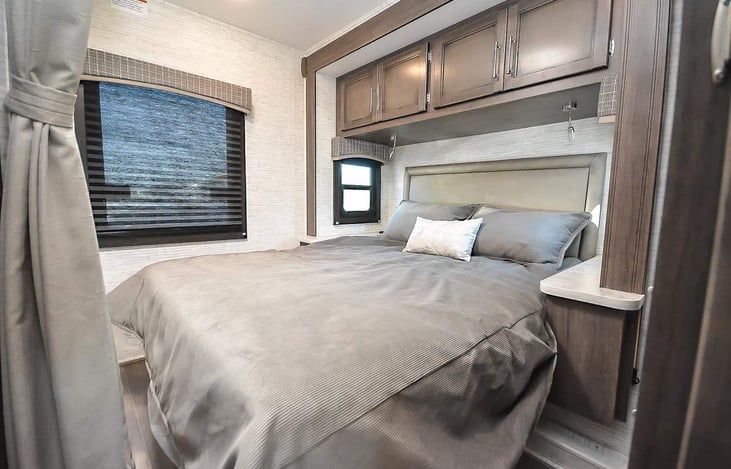 Queen Size bed with full walk around space.  Night stands with wireless phone charging and 110v outlets