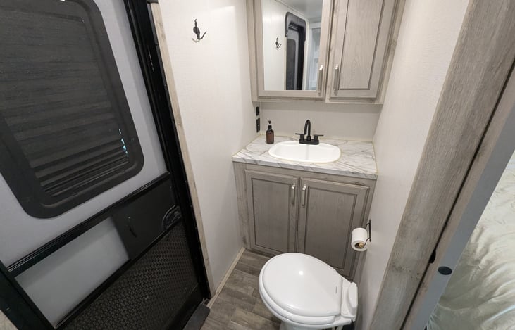 Privacy and convenience! This second full bath features a walk-in shower, porcelain toilet, and its own exterior entrance—perfect for quick access without tracking dirt through the whole rig.
