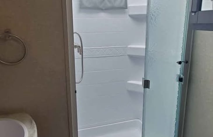 Full size shower, sink and toilet with storage space