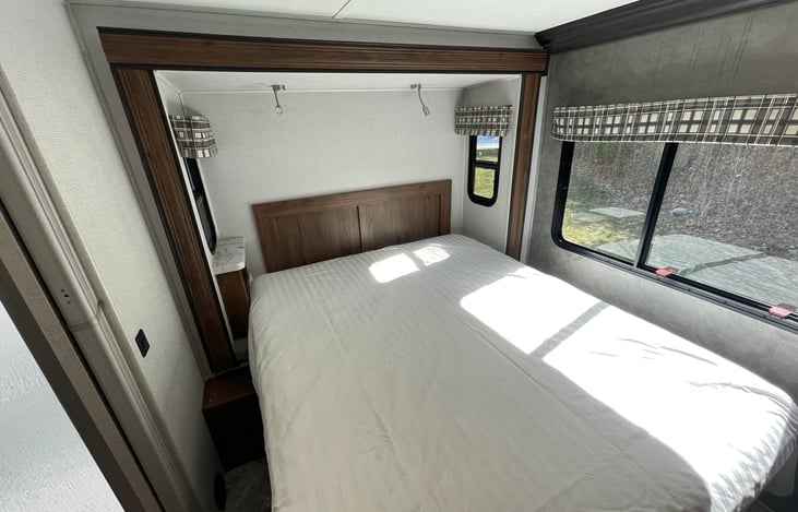 Queen RV sized mattress and overhead lighting.