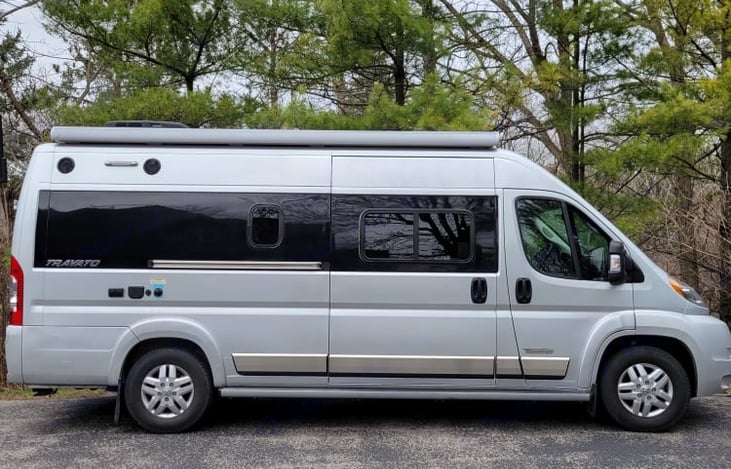 Passenger side of van.  External speakers, power outlet, black tank outlet flush.