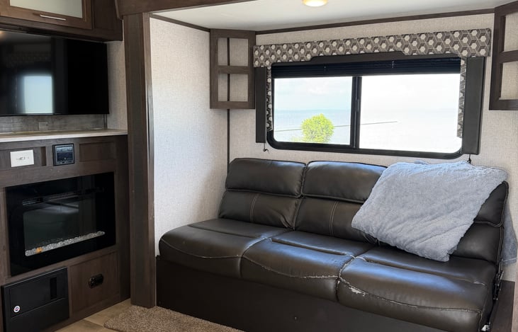 Comfortable jack-knife leather sofa with overhead storage—perfect for relaxing after a day outdoors.