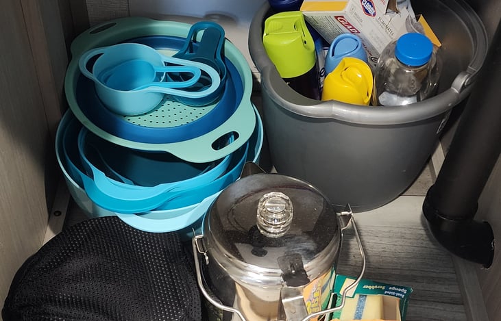 Cleaning supplies, mixing bowls/measuring cups/strainer, coffee pot, pots & pan (black bag).