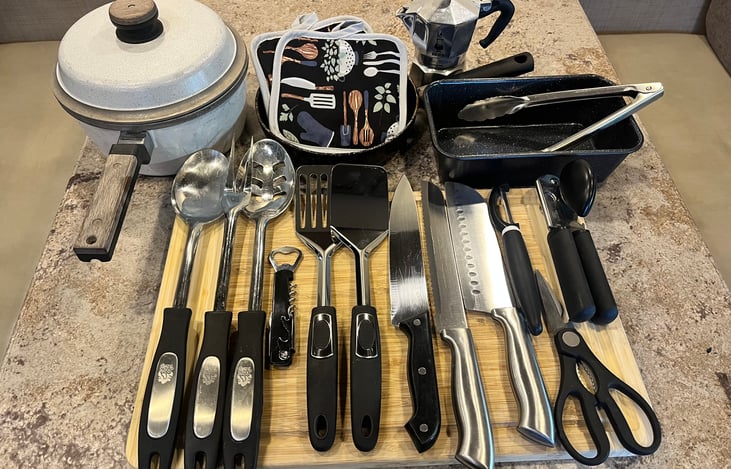 1 Pot w/Top, 1 Round Pan, 1 Rectangular Pan, 1 Espresso Maker, 2 Serving Spoons, 2 Spatula, 3 Knives, 1 Bottle Opener, 1 Peeler, 1 Can Opener, 1 Pair of Scissors, 1 Pair of Tongs, 2 Pot Holders