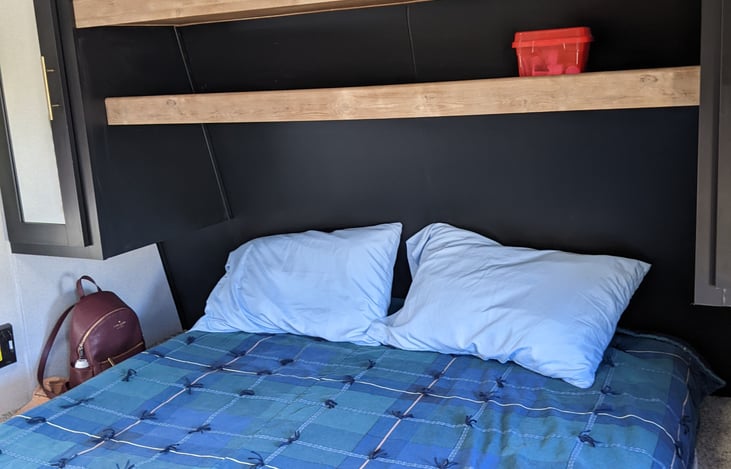 Queen master bed with bedding.