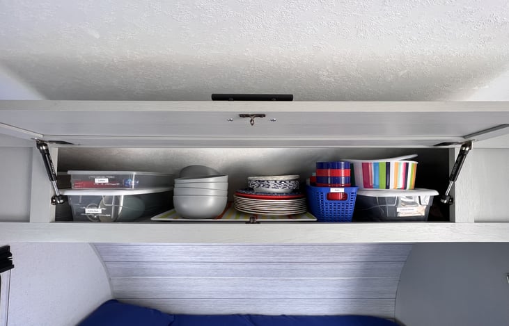 Storage above queen murphy bed holds majority of the supplies provided.