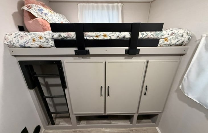 Bunk on Right side of trailer with cabinets.