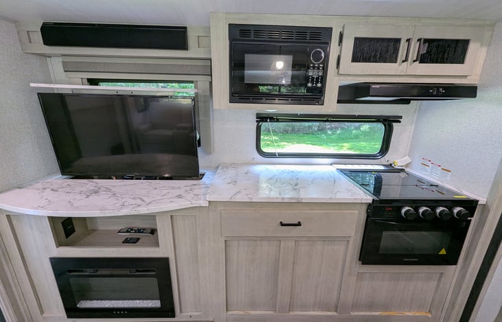 Bright, spacious and luxurious interior. Well-equipped kitchen with island and large refrigerator. Telescoping TV with fireplace. Ample storage. Cozy recliners. Large windows for natural light.