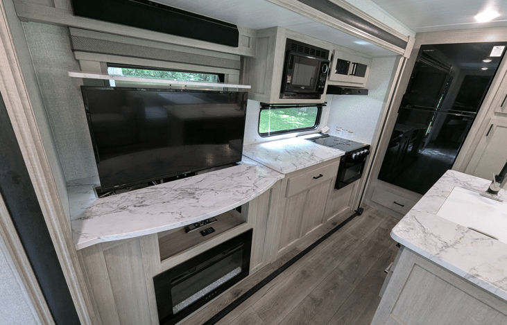 Bright, spacious and luxurious interior. Well-equipped kitchen with island and large refrigerator. Telescoping TV with fireplace. Ample storage. Cozy recliners. Large windows for natural light.