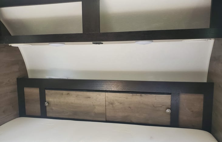 Headboard area with overhead shelf and built in LED lights. You also have a couple of USB outlets and storage cabinet with doors.
