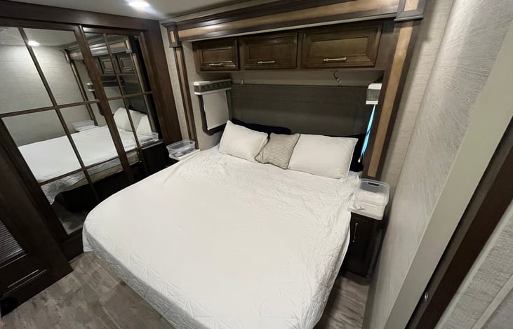 Bedroom with king size bed. Full length hanging closet behind mirrors.