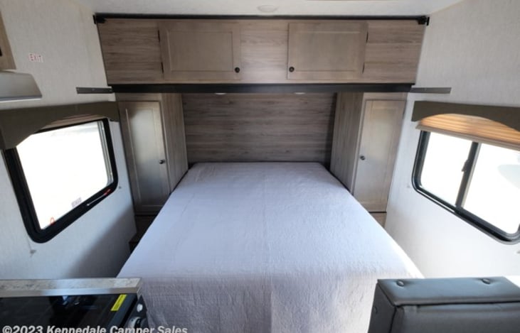 RV queen bed. Behind the closets is a place for a C-pap, etc. with 110v and USB power.