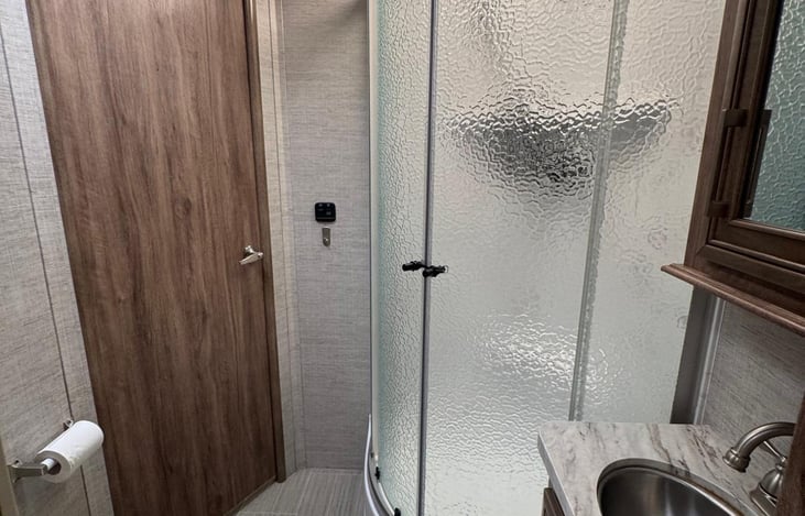 Restroom with a full shower and sink.
