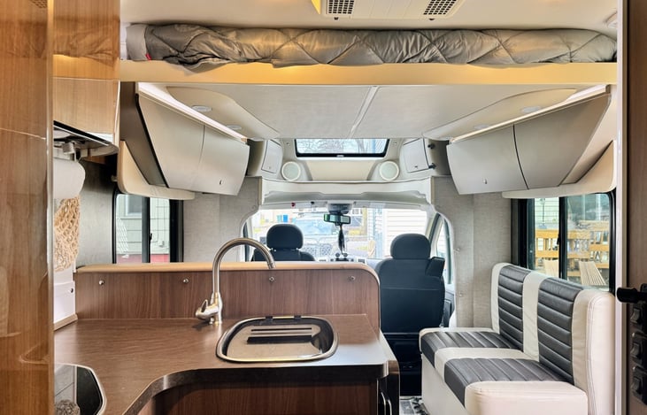 View from the kitchen! The top bed is a loft that comes down at the press of a button, sleeping one comfortably. Our Viva has clean, well kept surfaces, and the leather dinette seats are easy to clean