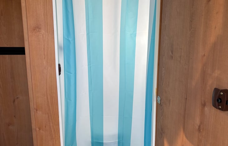 wet bath has a shower curtain and a regular door