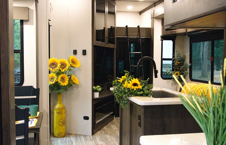 What's that ladder for over there? Well that's somebodies favorite bunk up there. BIG TV, one of four, in this camper. Fireplace & entertainment center as well.