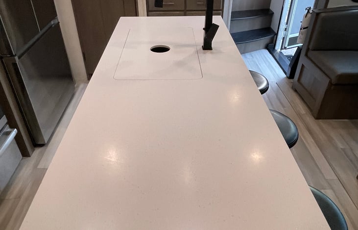 Large island with double / split sink that has covers to maximize counter space.