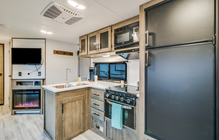 Perfect kitchen area with good size fridge and freezer that works on propane and electric. Double sink with stove and microwave.
