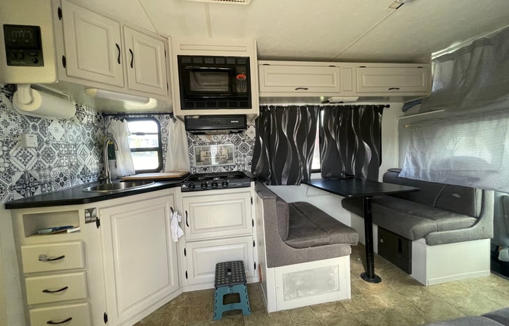 Sink, stove and dining table. Microwave.