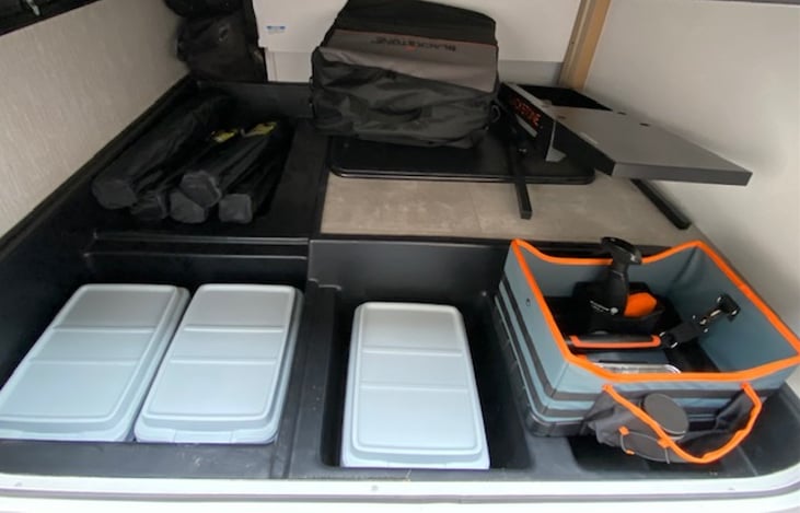 Lots of storage, comes equipped with 5 camp chairs, card table, Blackstone grill (and grill utensils), and all hook-up needs