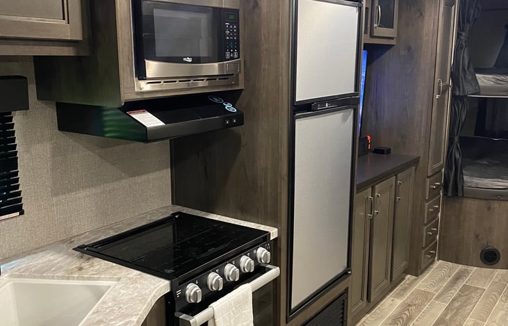 Refrigerator with freezer. It can run on propane if needed. 3 burner cooktop with oven. It also runs on gas. Electric microwave.