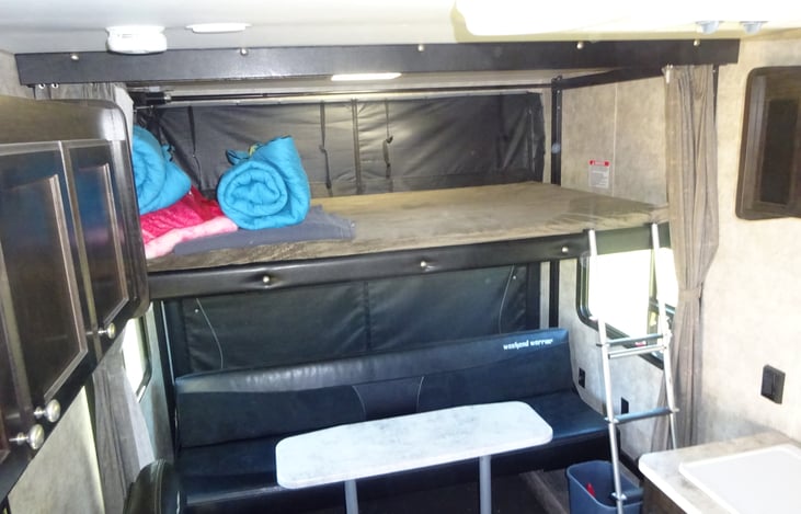 Happijack bed ready for sleeping with couch left set up for use.